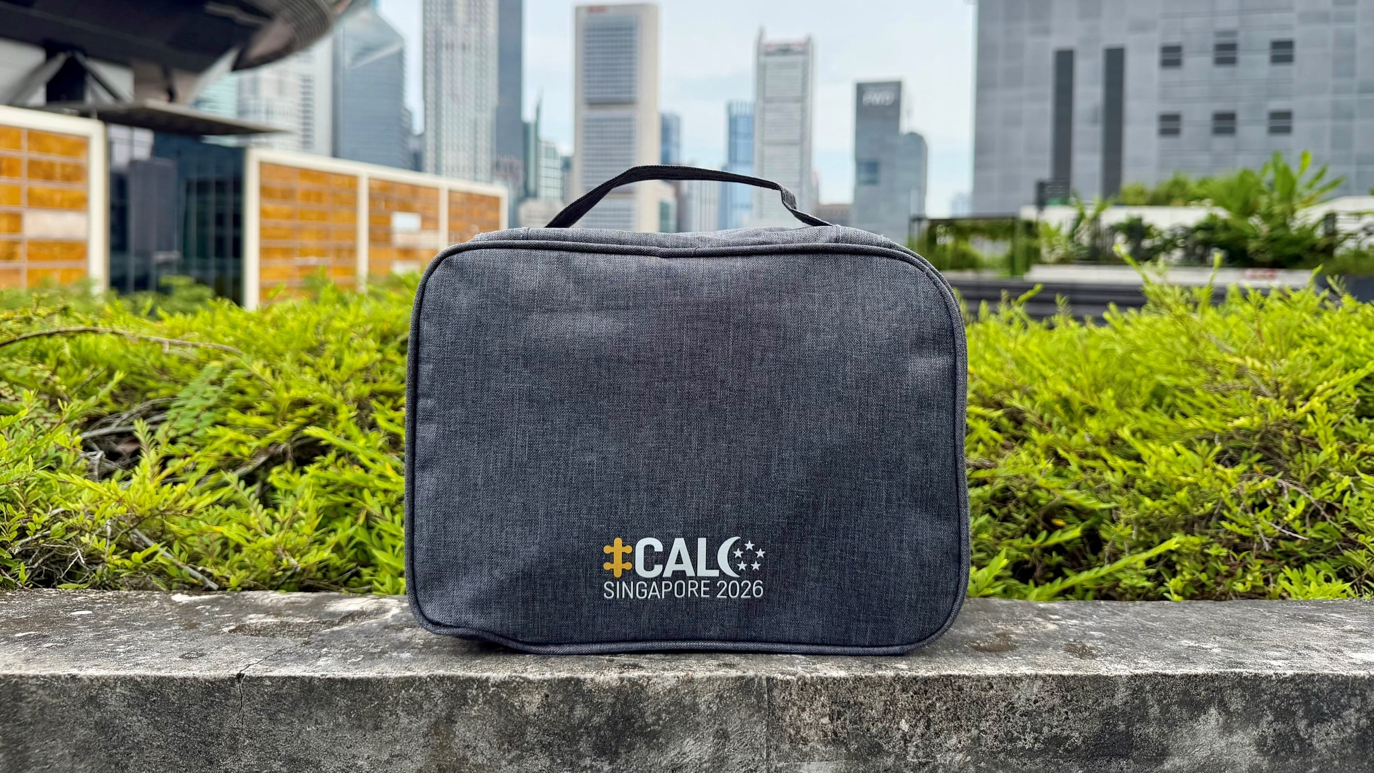 Travel organiser bag with CALC Singapore 2026 logo set against skyscrapers